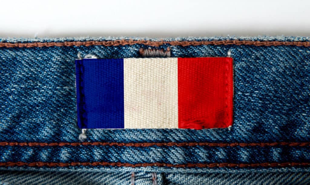 Une pièce de tissus en jean avec un drapeau français cousus dessus.